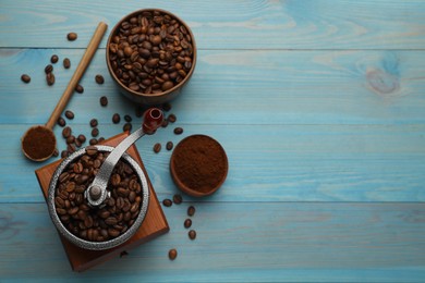 Vintage manual coffee grinder with beans and powder on light blue wooden table, flat lay. Space for text