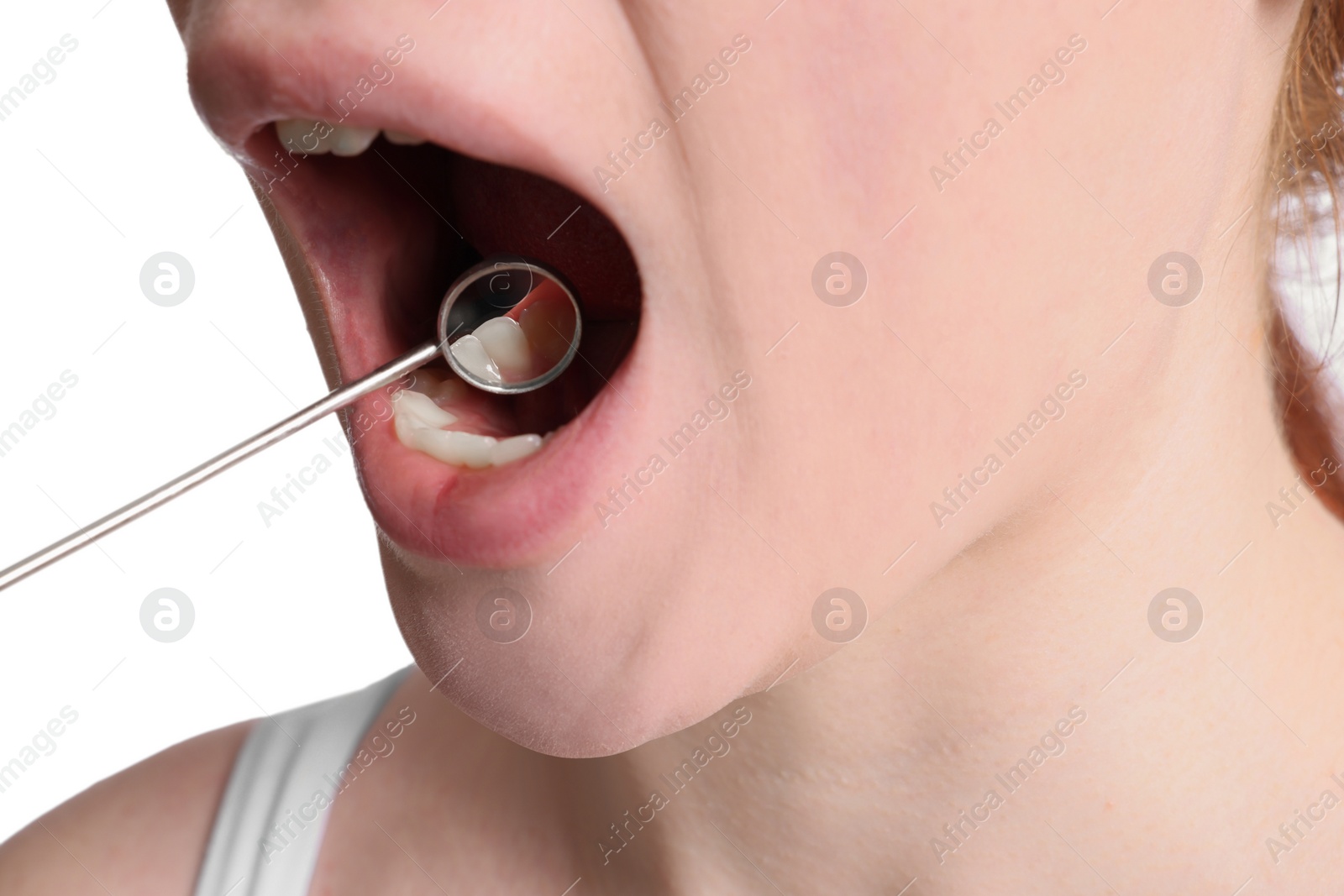 Photo of Examining young woman's teeth and gums with mirror on white background, closeup