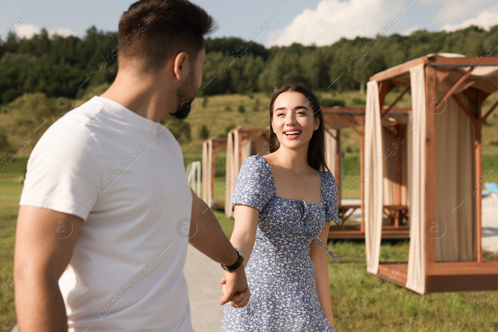 Photo of Romantic date. Beautiful couple walking outdoors on sunny day