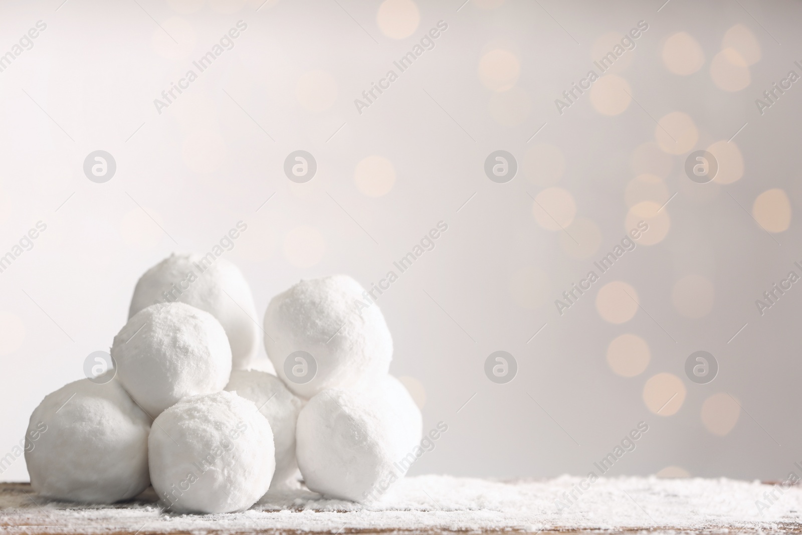 Photo of Snowballs on table against blurred lights, space for text