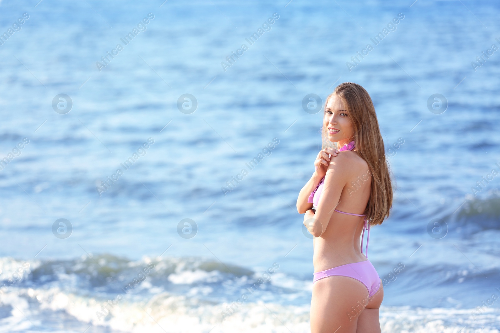 Photo of Attractive young woman in beautiful bikini swimsuit on beach