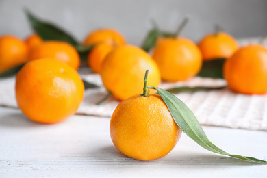 Photo of Fresh ripe tangerine on white wooden table