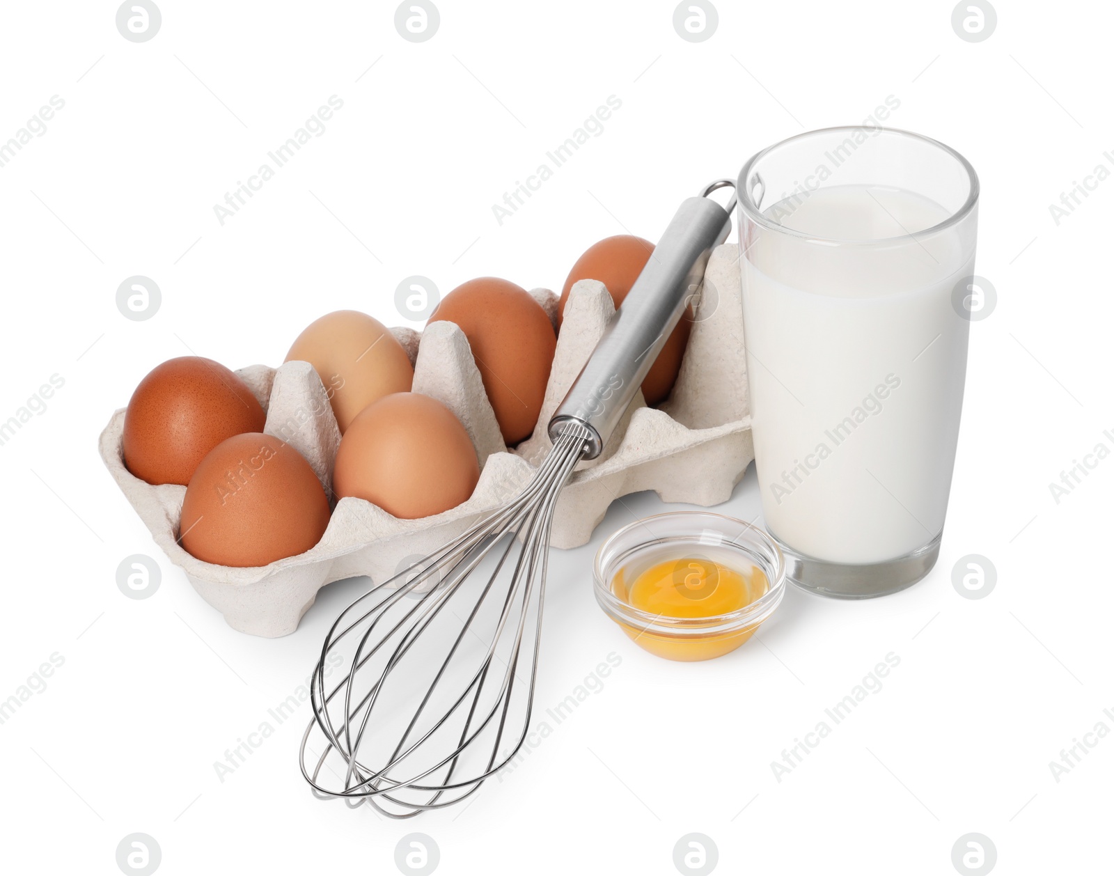 Photo of Metal whisk, raw eggs and glass of milk isolated on white