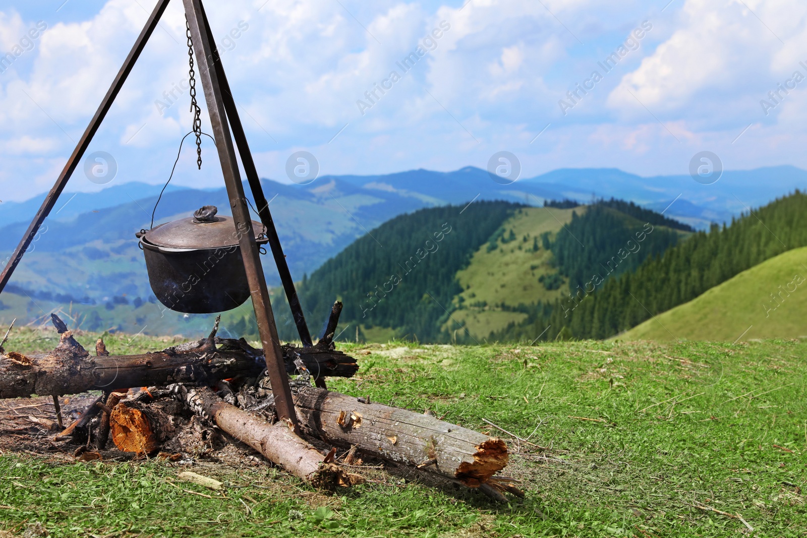 Photo of Cooking breakfast on fire in mountains. Camping season