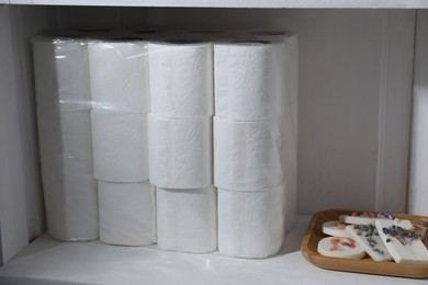 Photo of Toilet paper rolls and soap on white shelf