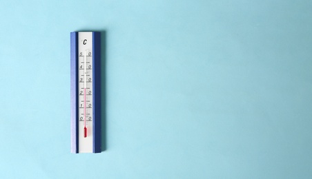 Photo of Weather thermometer on light blue background, top view. Space for text