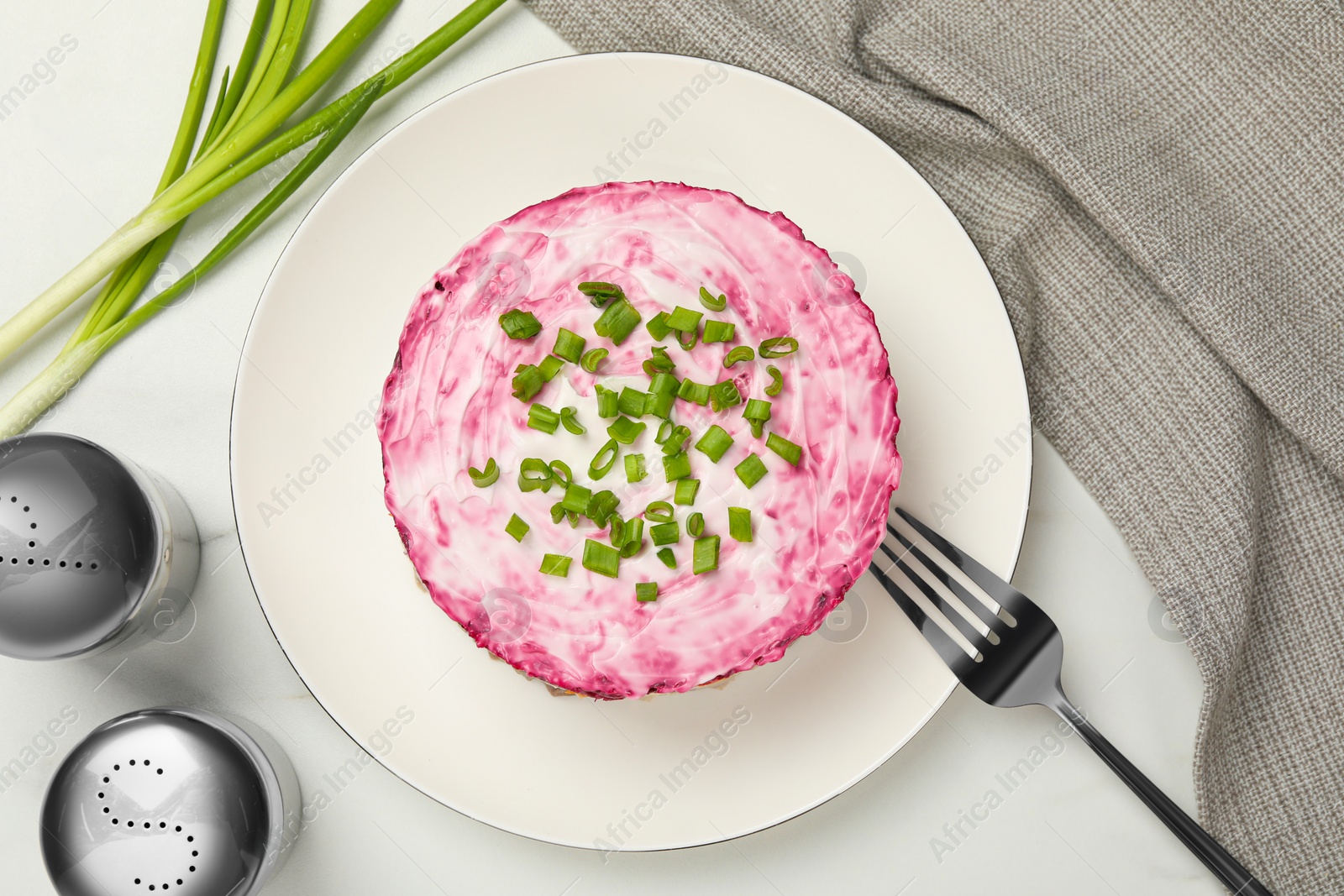 Photo of Herring under fur coat salad served on white table, flat lay. Traditional Russian dish