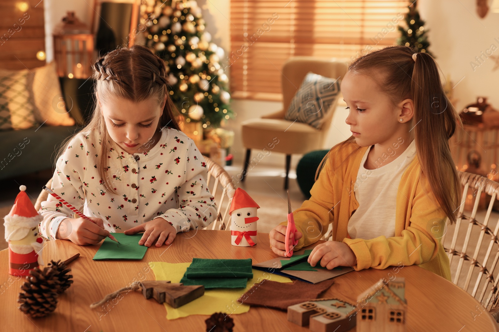 Photo of Cute children making Christmas greeting card at home