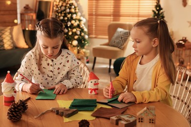 Cute children making Christmas greeting card at home