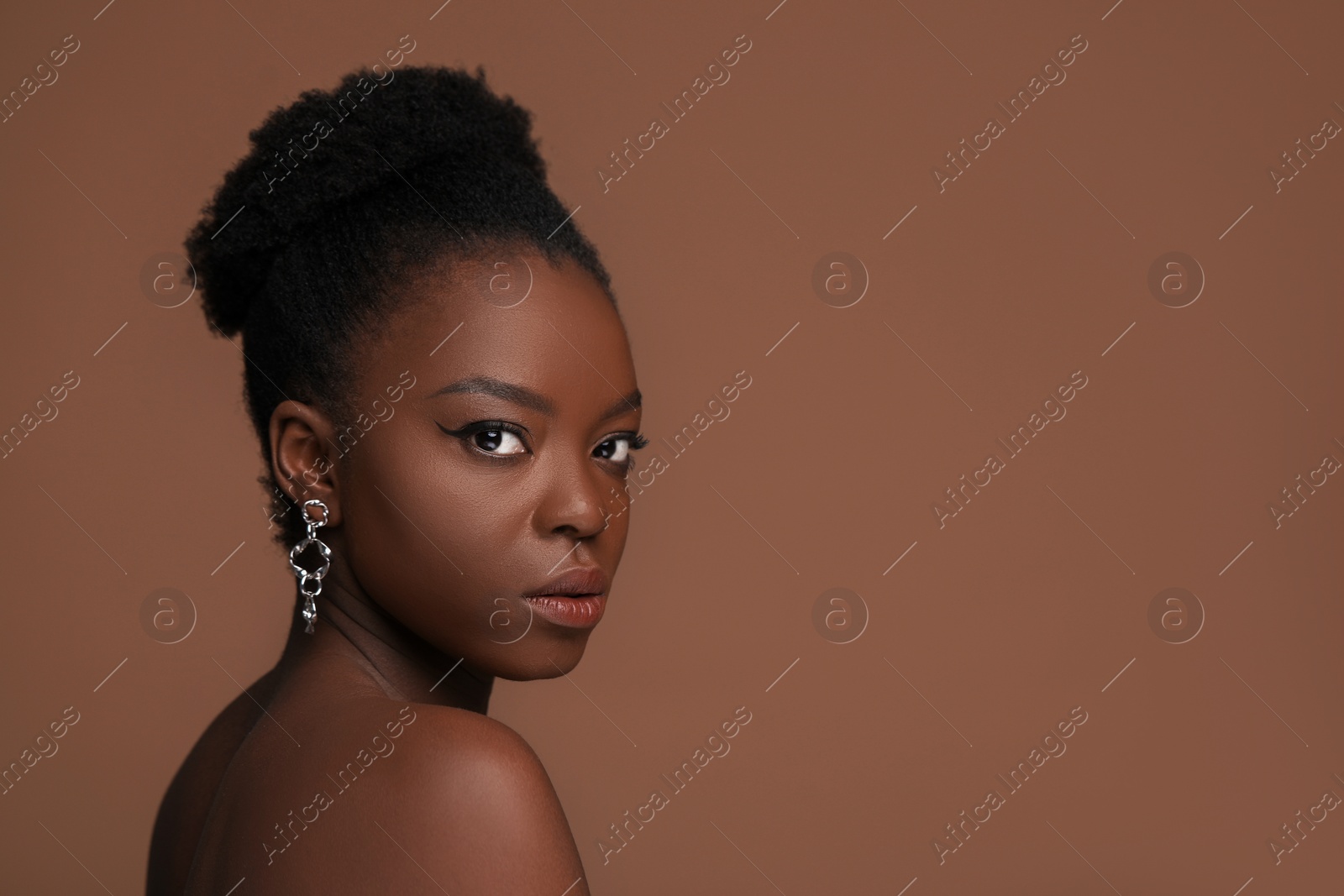 Photo of Fashionable portrait of beautiful woman on light brown background, space for text