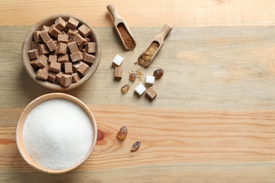 Photo of Various kinds of sugar in bowls on wooden background