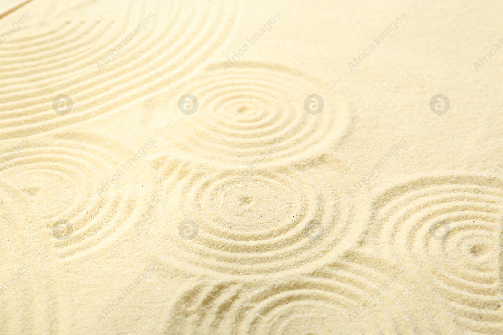 Photo of Zen rock garden. Circle patterns on beige sand