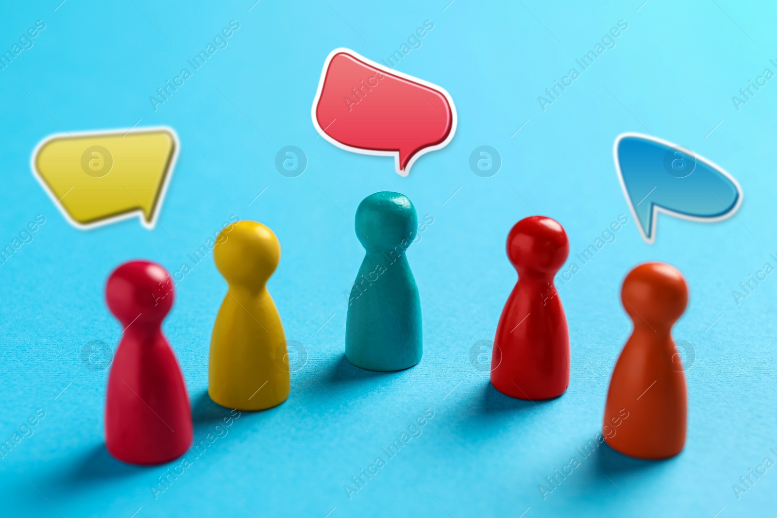 Image of Productive dialogue, meaningful conversation, considerable discussion. Speech bubbles over colorful pawns on light blue background
