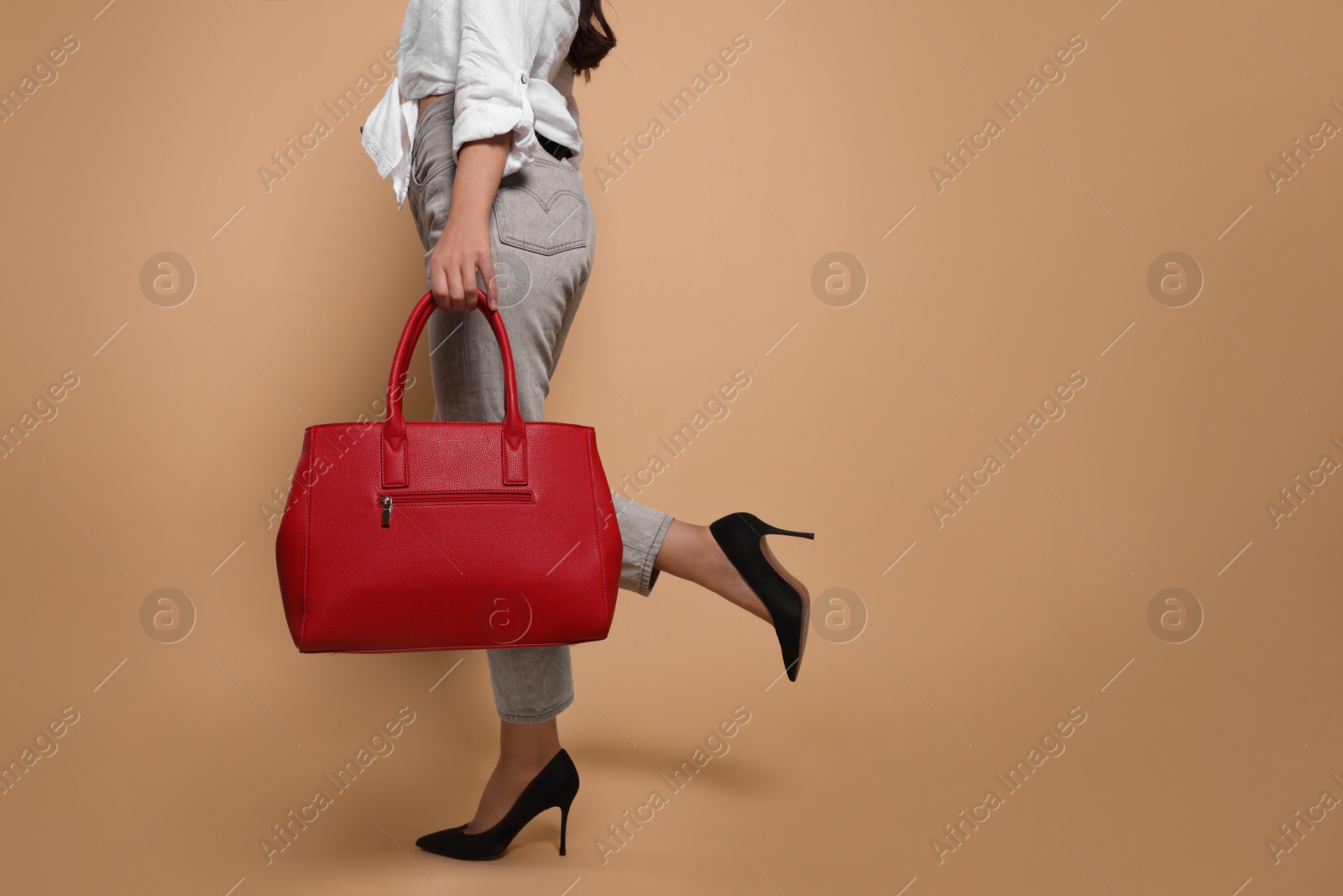 Photo of Young woman with stylish bag on beige background, closeup. Space for text