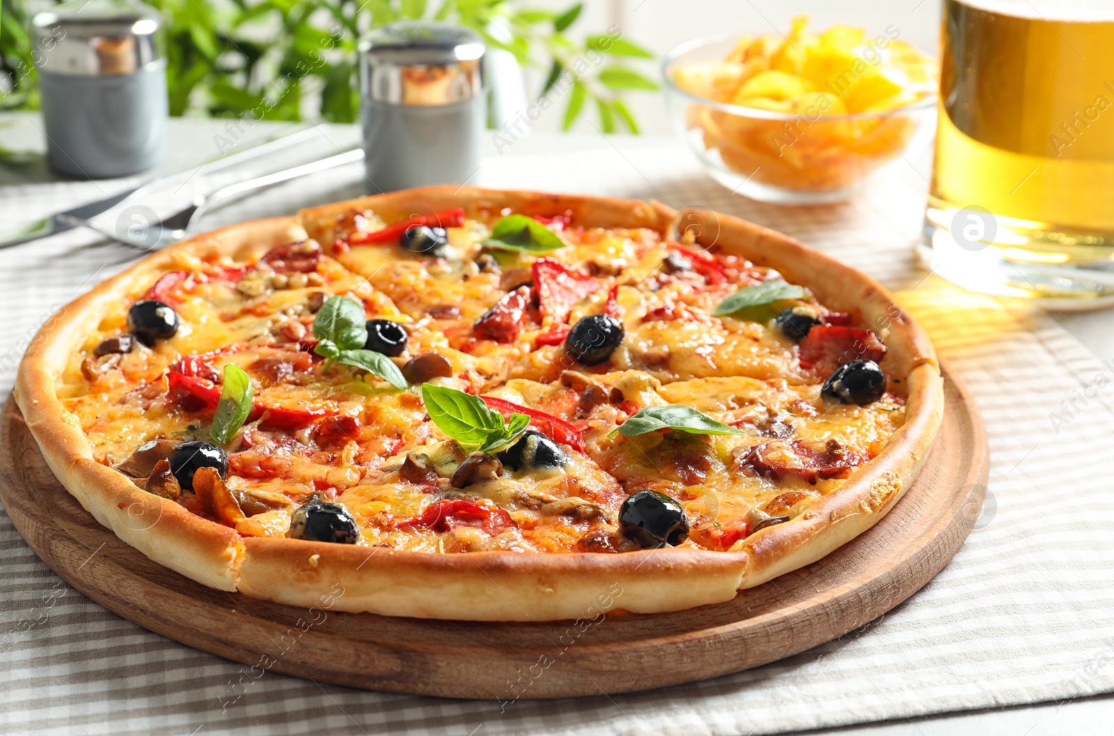 Photo of Delicious pizza with olives and sausages on table