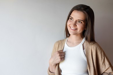 Photo of Portrait of beautiful young woman on beige background, space for text