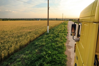 Man driving modern truck on country road. Space for text