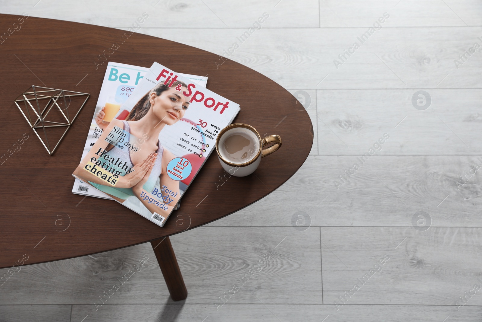 Photo of Magazines and cup of coffee on wooden table indoors, above view. Space for text