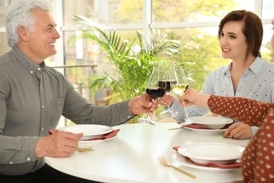 Photo of People with glasses of wine at table in restaurant