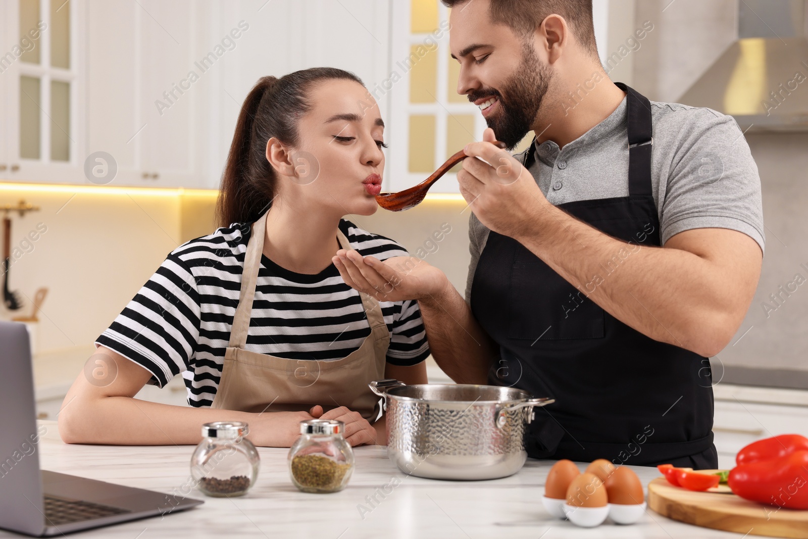 Photo of Lovely young couple cooking together in kitchen