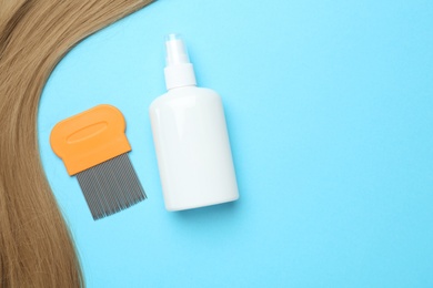 Comb and anti lice spray, blond hair on light blue background, flat lay. Space for text