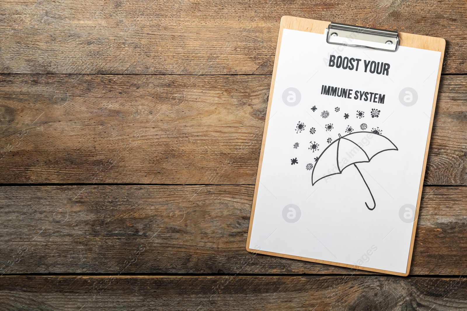 Photo of Clipboard with phrase Boost Your Immune System on wooden table, top view. Space for text