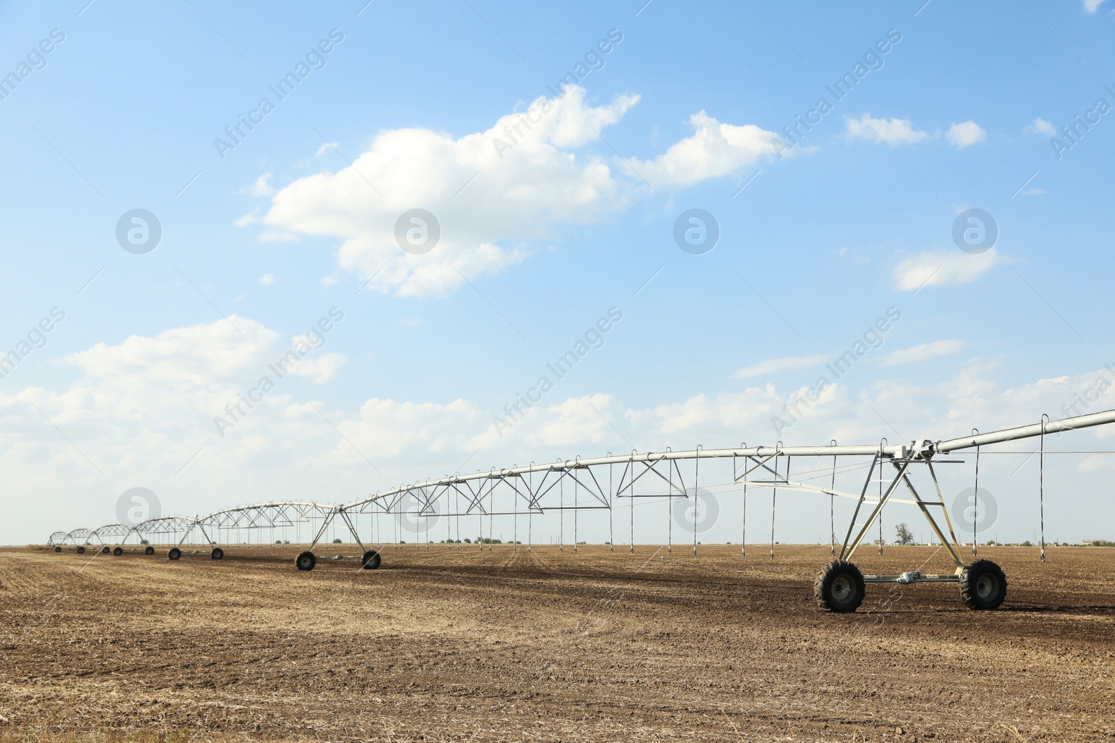 Photo of Field with irrigation system on sunny day