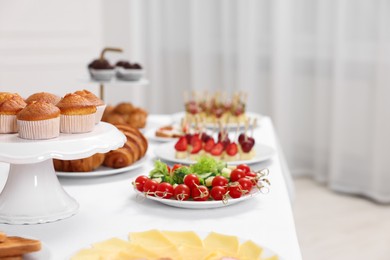 Different meals served on white table indoors. Buffet menu