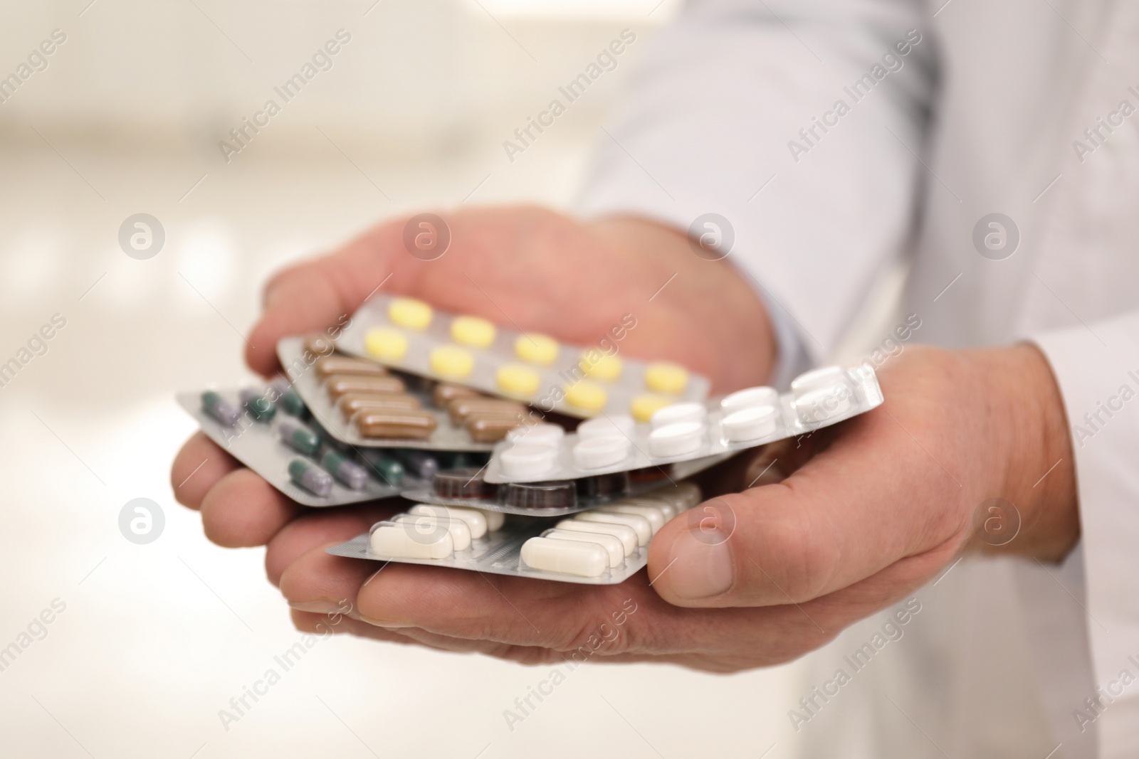 Photo of Senior pharmacist with pills on blurred background, closeup
