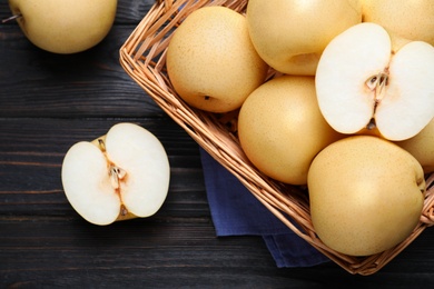 Cut and whole apple pears on black wooden table, flat lay