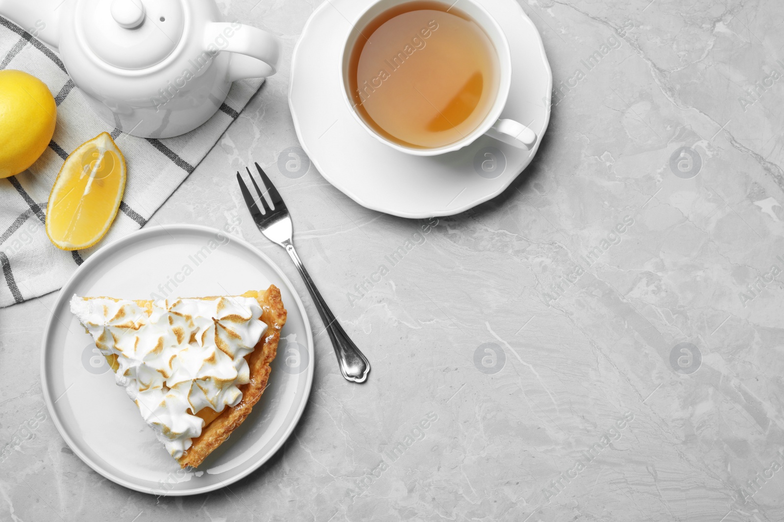 Photo of Delicious lemon meringue pie served on light grey table, flat lay. Space for text