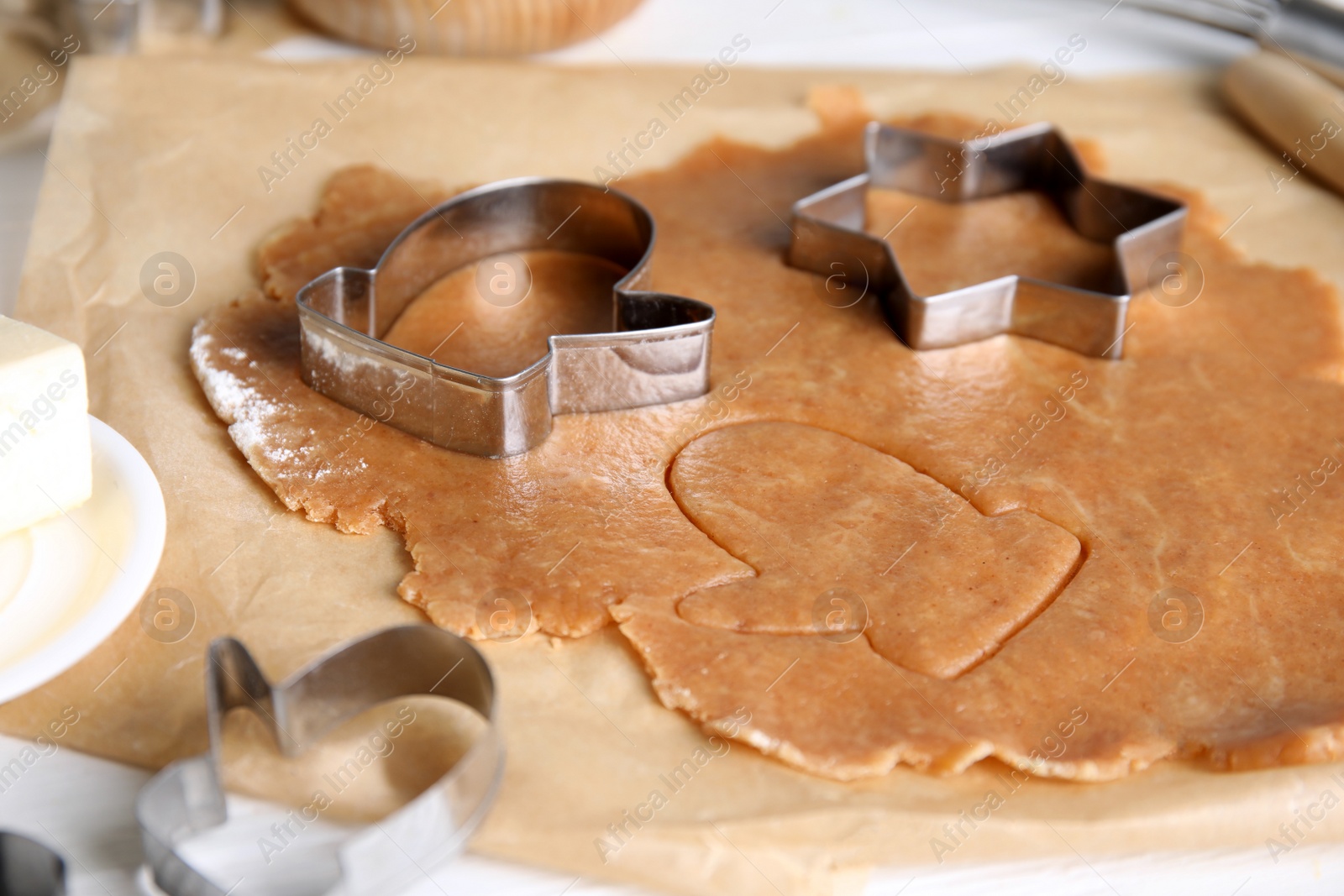 Photo of Making homemade Christmas cookies. Dough and cutters on table, closeup