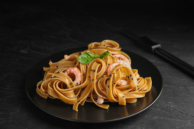 Tasty buckwheat noodles with shrimps on black table