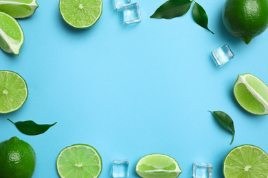 Photo of Flat lay composition with fresh juicy limes and ice cubes on light blue background. Space for text