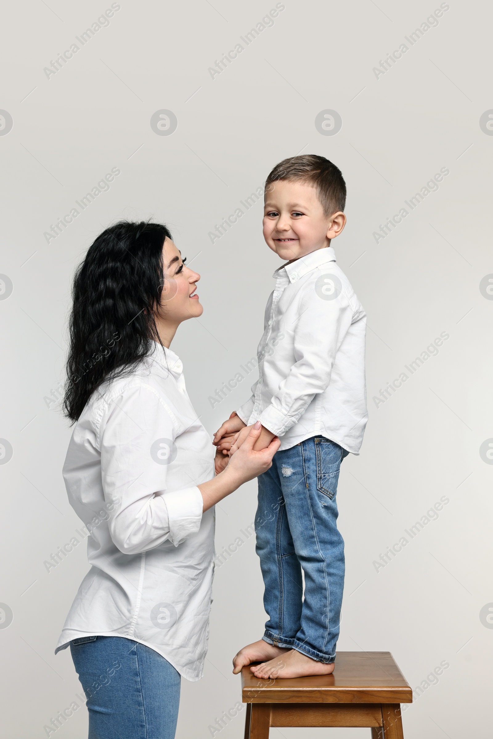 Photo of Beautiful mother with little son on white background