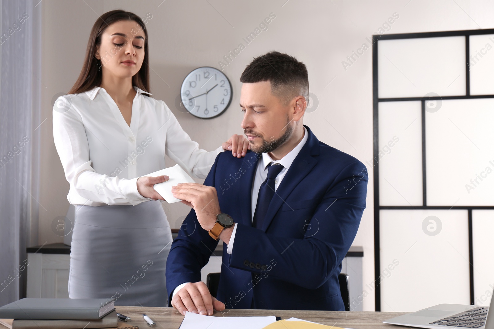 Photo of Woman giving bribe to man at table in office