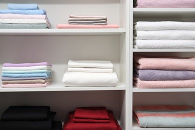 Photo of Different color linens on shelves in shop