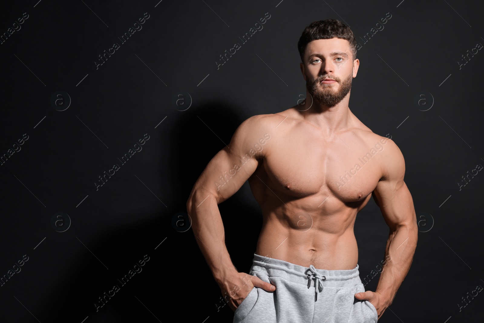 Photo of Handsome muscular man on black background, space for text. Sexy body