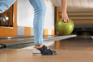 Young woman throwing ball in bowling club, closeup