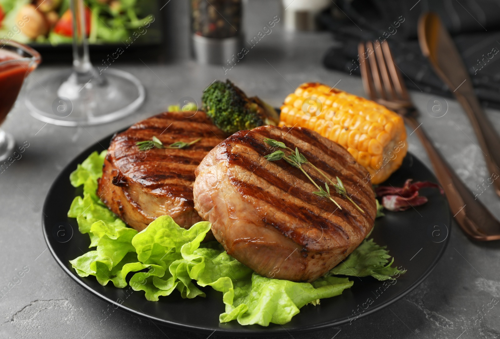 Photo of Delicious beef medallions served on grey table, closeup