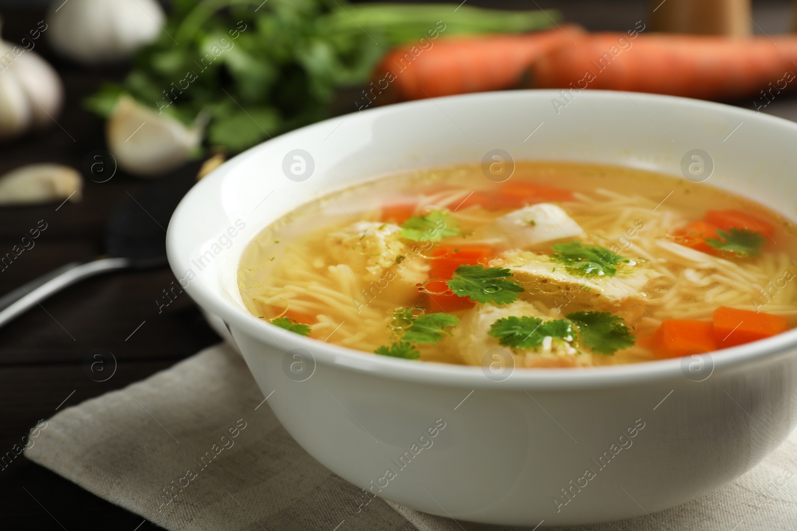 Photo of Plate with fresh homemade chicken soup on table, closeup