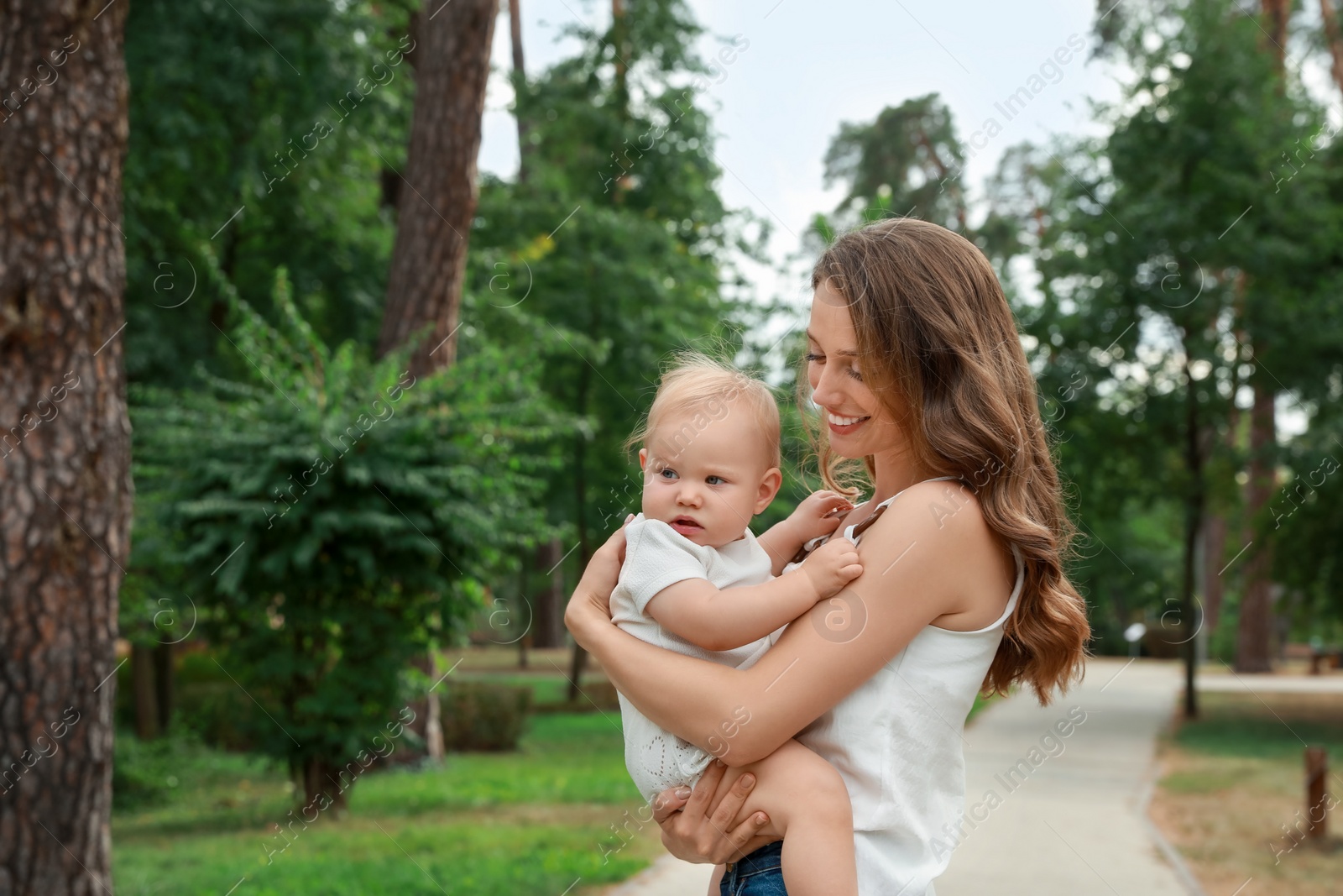 Photo of Mother with her cute baby spending time together outdoors. Space for text