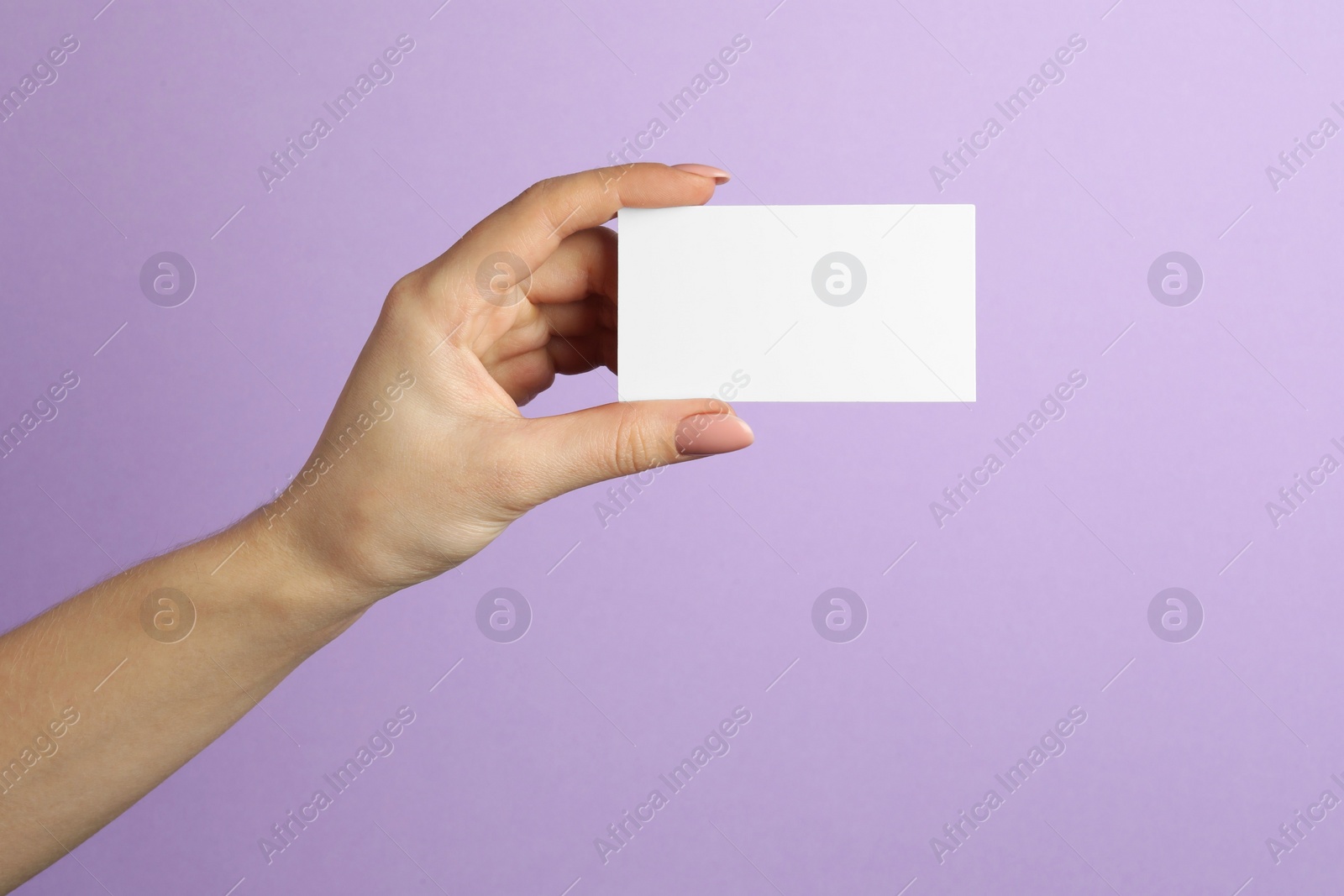 Photo of Woman holding blank business card on violet background, closeup. Mockup for design