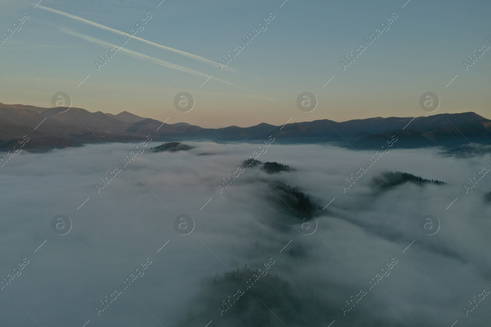 Photo of Aerial view of beautiful mountains covered with fluffy clouds in morning