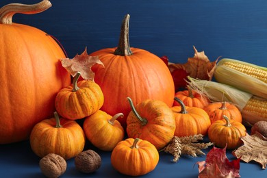 Photo of Thanksgiving day. Composition with pumpkins on blue wooden table, closeup