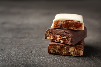 Photo of Tasty protein bars on grey table. Space for text