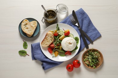 Photo of Delicious burrata salad served on white wooden table, flat lay