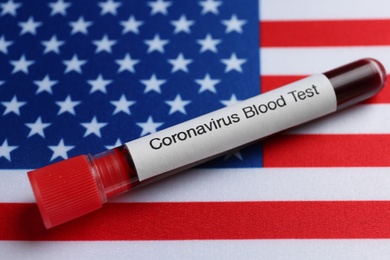 Photo of Test tube with blood sample on American flag. Coronavirus pandemic in USA