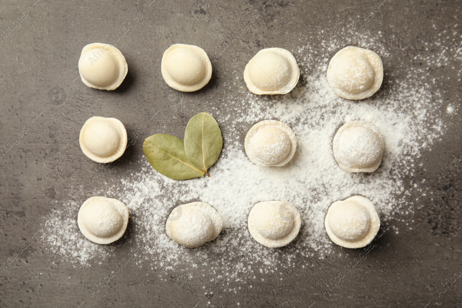 Photo of Flat lay composition with raw dumplings on grey background