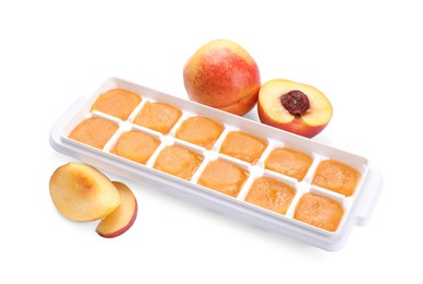 Photo of Nectarine puree in ice cube tray and ingredients on white background. Ready for freezing